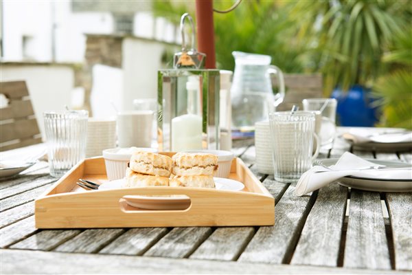 Garden table with tray, cream tea and drinks